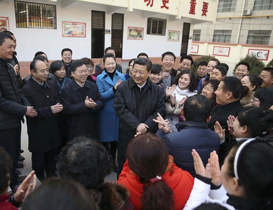 2015年2月14日上午，習近平在延安市楊家嶺福州希望小學視察后，與聞訊趕來的附近群眾親切交流并向大家拜年。 新華社記者 蘭紅光 攝